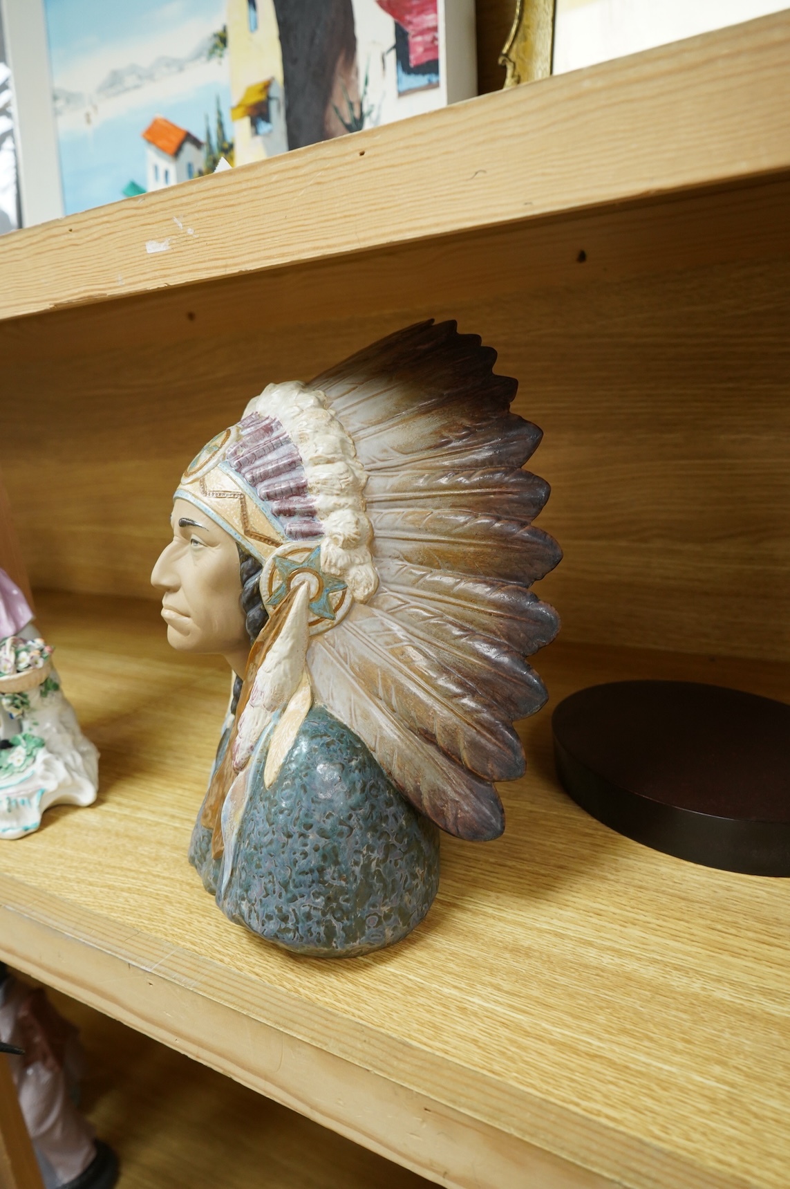 A Lladro bust of a native America chief with feather tribal headdress, 29cm high. (Bust on stand)